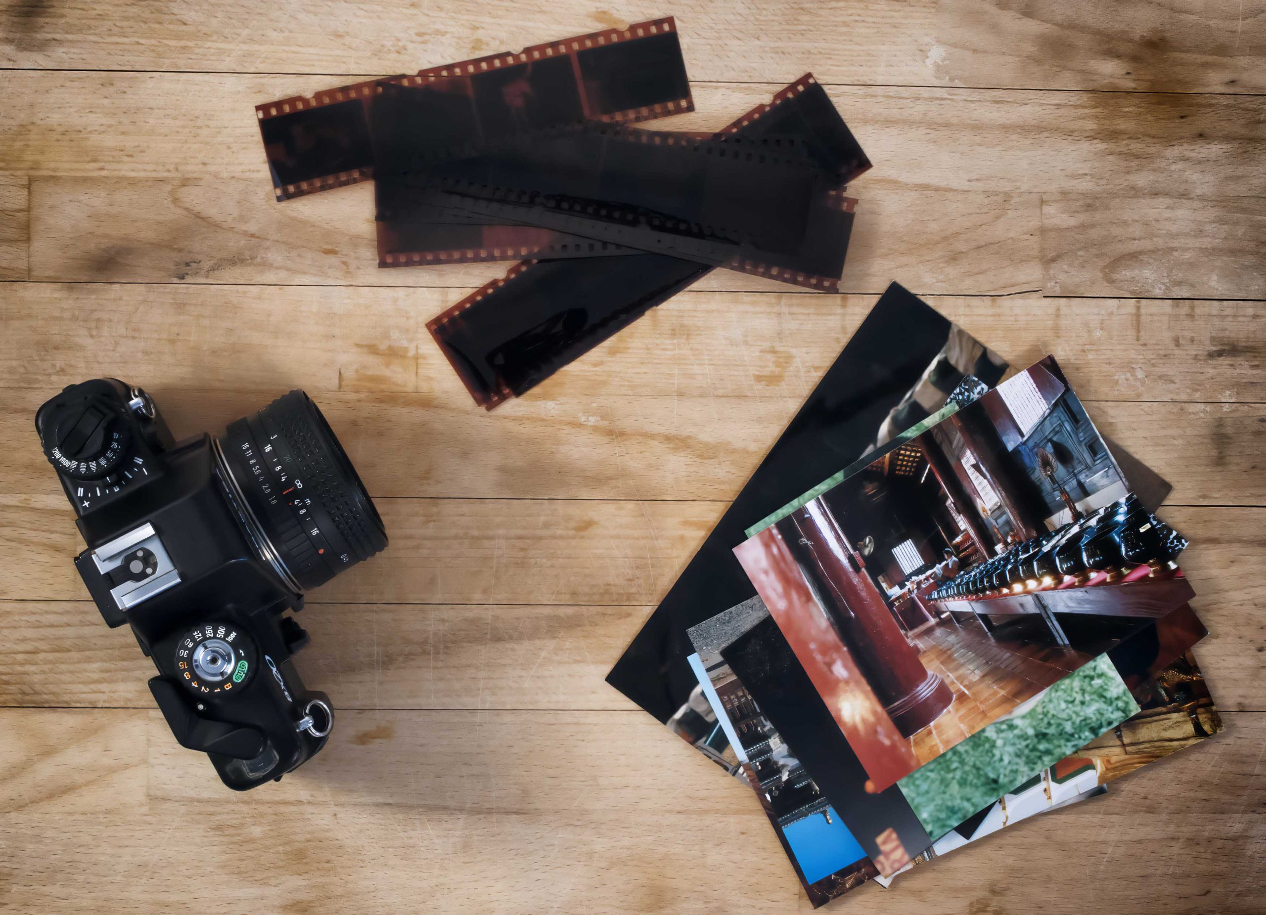 camera film and photos on wooden background